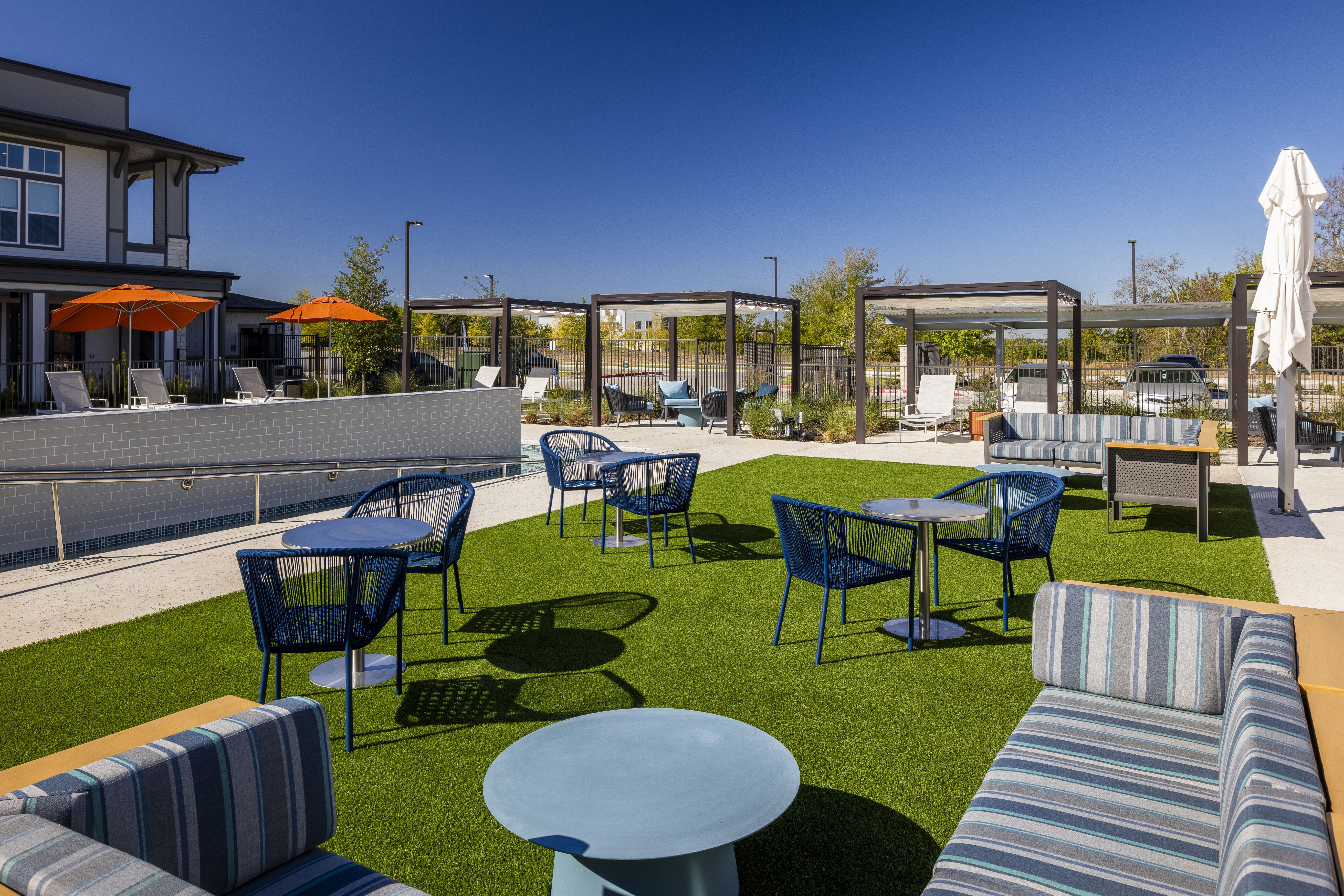 a lounge area with tables and chairs on the grass